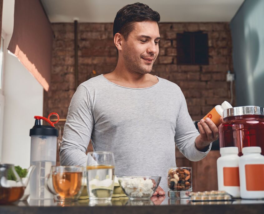 Man reading label on supplement bottle