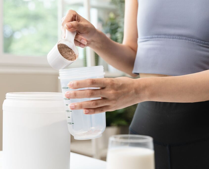 Person putting poweder supplement in drink