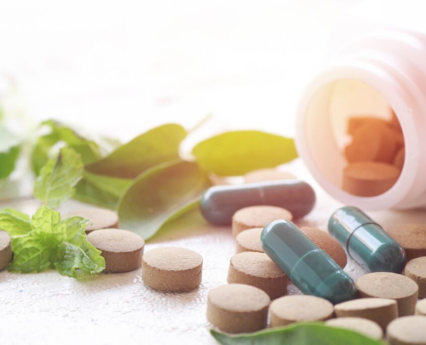 Side view of a pill bottle with poured out pills